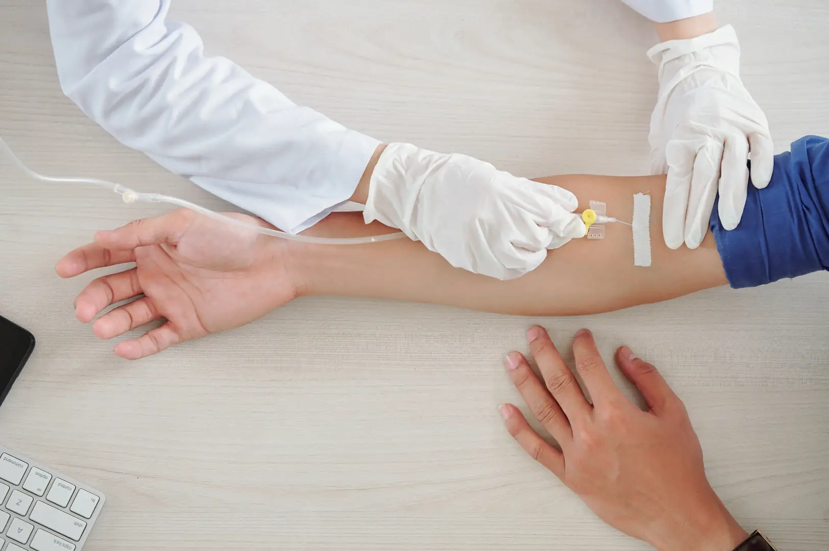 A nurse setting up a drip in a patient's arm.